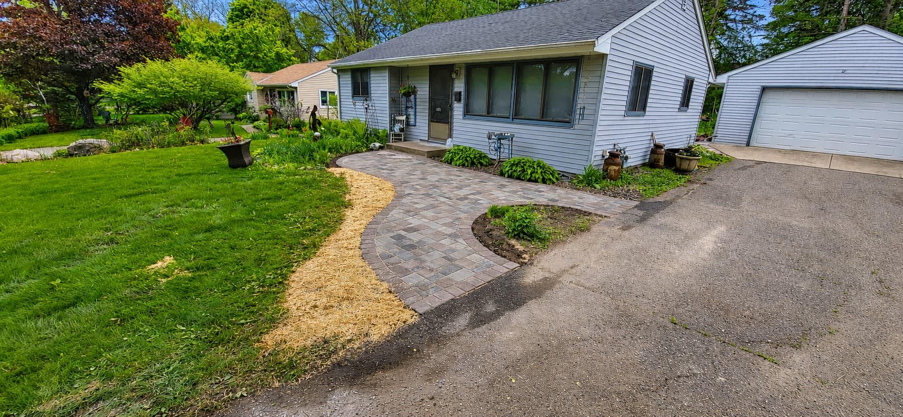 Curved paver walkway leading to a home's front entrance