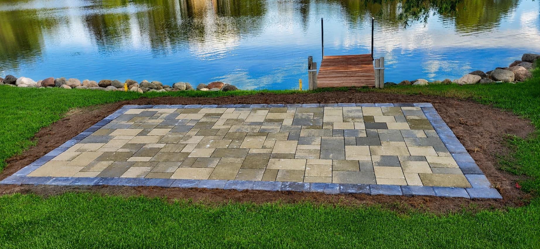 Lakeside paver patio pad beside a dock